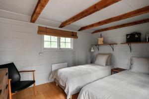 two beds in a room with white walls and a window at Luxury family home near the water for eight people in Stockholm