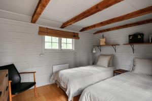 2 letti in una camera con pareti bianche e finestra di Luxury family home near the water for eight people a Stoccolma