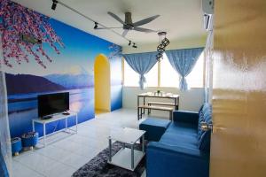 a living room with a blue couch and a tv at Fuji Home in Bayan Lepas