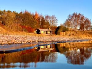 una casa en una colina junto a un cuerpo de agua en Whitemoor Lodge, en Barnoldswick