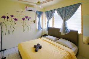 a bedroom with a bed with purple flowers on the wall at Fuji Home in Bayan Lepas