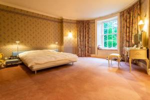 a bedroom with a large bed and a window at 18th Century Manor with Sauna 