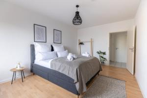 sypialnia z dużym łóżkiem z białymi poduszkami w obiekcie Modernes und Zentralgelegenes Apartment mit Küche, Netflix, und Balkon w mieście Duisburg