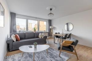 ein Wohnzimmer mit einem Sofa und einem Tisch in der Unterkunft Modernes und Zentralgelegenes Apartment mit Küche, Netflix, und Balkon in Duisburg