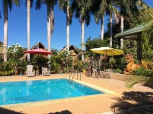 een zwembad met stoelen en parasols in een resort bij Himawari Restaurant & Cottage in Ban Nong Hin