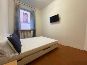 een slaapkamer met een bed en een tv aan de muur bij Les Tres Chic in Cesena