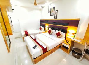 1 dormitorio con 2 camas y escritorio en Gateway Suites, en Bombay