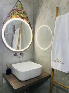 ein Badezimmer mit einem weißen Waschbecken und einem Spiegel in der Unterkunft Gea Kaimaktsalan Hotel & Spa in Kato Loutraki
