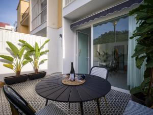 eine Flasche Wein auf einem Tisch auf einer Terrasse in der Unterkunft Cosmopolitan Design By CanariasGetaway in Las Palmas de Gran Canaria