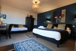 a bedroom with two beds and a table and a desk at La Haute Flourie - bed and breakfast -chambres d'hôtes in Saint Malo
