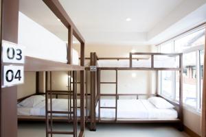 2 łóżka piętrowe w pokoju z oknem w obiekcie Studio'Z w mieście Chiang Mai