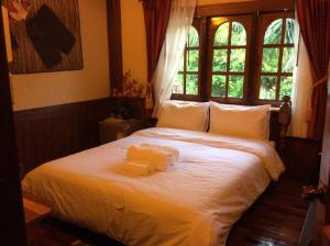 een slaapkamer met een bed met twee handdoeken erop bij Himawari Restaurant & Cottage in Ban Nong Hin +59 foto's