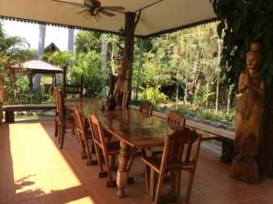 een houten tafel en stoelen op een terras bij Himawari Restaurant & Cottage in Ban Nong Hin