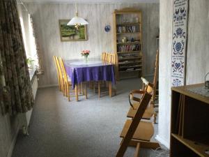 een eetkamer met een paarse tafel en stoelen bij Aadal Apartment in Karup