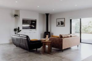 sala de estar con 2 sofás y chimenea en Scandi at Stieglitz Sleeps 6 Modern & Stylish, en St Helens