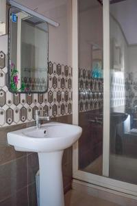 W łazience znajduje się umywalka, lustro i prysznic. w obiekcie Rajahamsam Houseboat w mieście Kumarakom