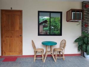 uma mesa e cadeiras num quarto com uma porta em La casa d aitor em Puerto Princesa