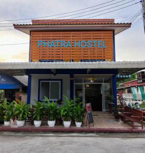 un hospital de terapia con macetas delante de él en Phatra Hostel, en Thong Sala