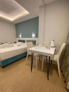 a bedroom with a bed and a table and chairs at Amsterdam Otel & Suite Apart in Kemer