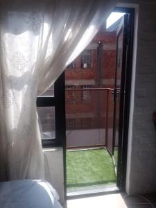 a window with a white curtain and a view of a yard at Located in the heart of the city in Johannesburg