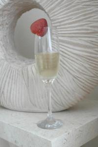 a glass of white wine with a strawberry in it at Sue's Apartment in Paphos