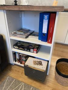 ein Bücherregal mit einer Spielkonsole und Büchern in der Unterkunft 2-Zimmer Ferienwohnung "Am Waldrand" in Schönwald