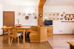 莫埃納的住宿－Delizioso appartamento trilocale a Moena，厨房配有木桌和电视。