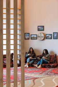 Due donne sedute su un divano in una stanza di ibis Jeddah City Center a Gedda