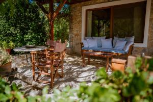 un patio con sofá, mesa y sillas en A Luxury Seafront Villa with amazing ambience and view, en Alyfantá