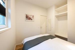 biała sypialnia z łóżkiem i oknem w obiekcie 90, gelegen aan het natuurmonument de Kampina w mieście Oisterwijk