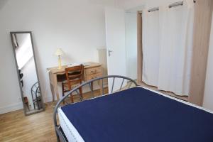 1 dormitorio con cama, escritorio y espejo en Appartement neuf proche de la mer en Beaussais sur Mer
