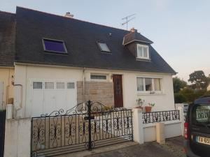 une maison blanche avec un toit noir et un portail dans l'établissement Appartement neuf proche de la mer, à Beaussais sur Mer