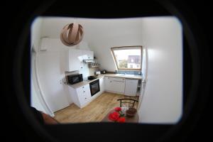 una pequeña cocina con armarios blancos y una ventana en Appartement neuf proche de la mer en Beaussais sur Mer