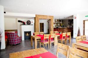 ein Esszimmer mit Tisch und Stühlen und einem Kamin in der Unterkunft Apartman #11 - Apartmanovy dom Ďumbier - Chopok Juh in Tale