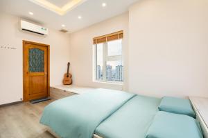 a bedroom with a large blue bed and a window at Căn hộ cao cấp 3 sao quận 10 - Hong Dao House in Ho Chi Minh City +29 photos