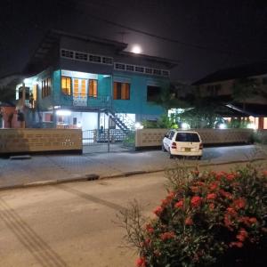 a car parked in front of a building at night at Max Garden and Pool in Paramaribo