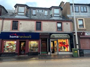 a store fronts on a street in front of a building at cosy 1 bed flat Largs in Largs