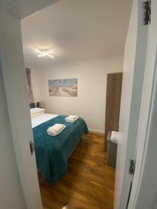 a bedroom with a bed with a green bedspread at cosy 1 bed flat Largs in Largs