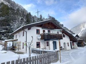 ein Haus im Schnee mit einem Zaun in der Unterkunft Fewo M & M in Scharnitz