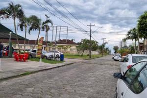 a street with cars parked on the side of the road at VELHO OESTE Carruagens, Casa Inteira !! in Matinhos