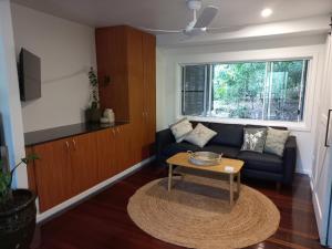 a living room with a couch and a table at Tropical Retreat on Magnetic Island in Picnic Bay