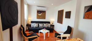 een woonkamer met een bed en stoelen en een tafel bij Casa con jardín a 40 metros de la playa. VR. in Palamós