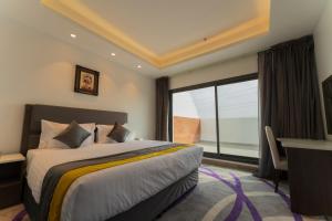 a bedroom with a bed and a desk and a window at Riyadha Home Apartment Economy in Riyadh +54 photos
