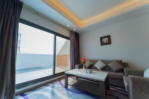 a living room with a couch and a large window at Riyadha Home Apartment Economy in Riyadh