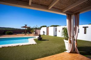 a backyard with a swimming pool and green grass at Villa Casa de campo Atrapasomnis in Benissa