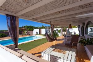 a patio with a couch and a table and a pool at Villa Casa de campo Atrapasomnis in Benissa