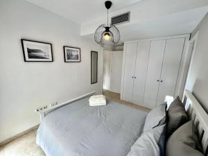 Acogedor apartamento entero في تيراسا: غرفة نوم بيضاء مع سرير وأريكة