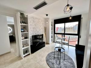 a living room with a table and a brick wall at Acogedor apartamento entero in Terrassa