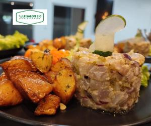 un plato de comida con patatas de carne y hortalizas en 2 0 HÔTEL Ylang en Labattoir