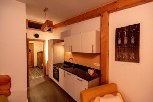 cocina con armarios blancos y encimera en Panorama Apartment Bauernhof Mandl, en Murau